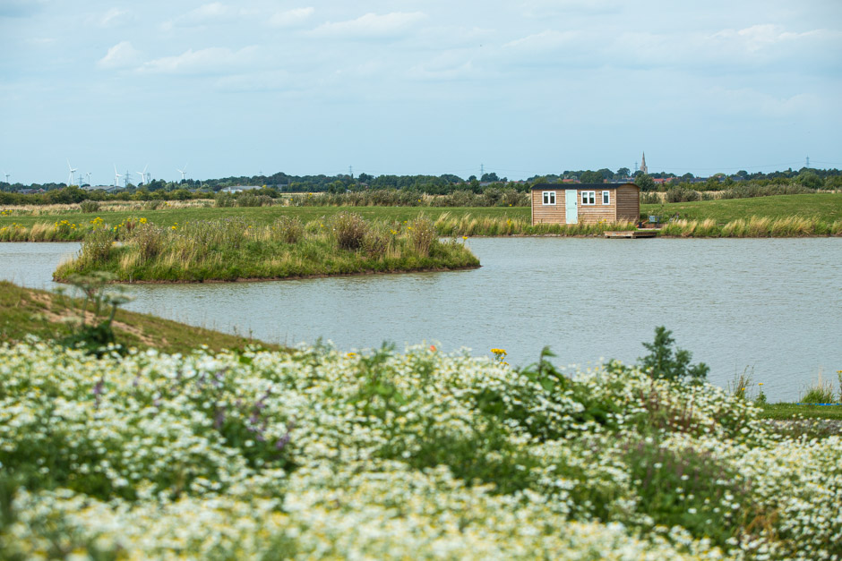 Cross keys shepherds hut situated in front of a lake with small island