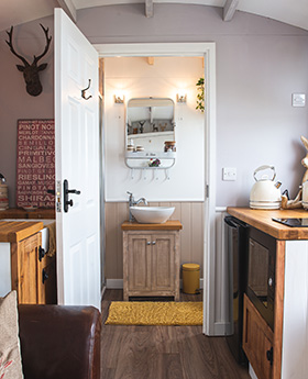 The inside of the shepherds hut is wooden with a modern rustic feel.