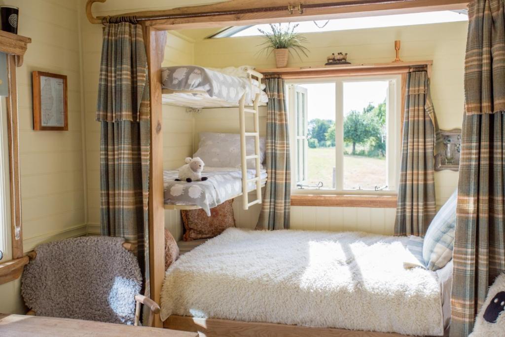 The interior of the shepherds hut shows it is great for young families with a double bed and 2 bunk beds positioned well in the space